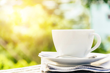 coffee cup clock and news paper on old wooden table