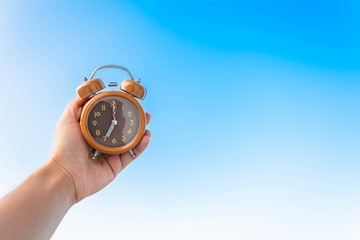 Brown clock in an hand