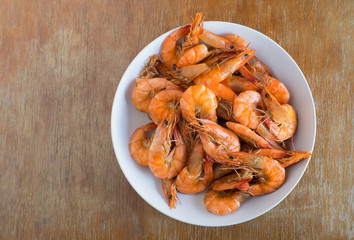 Shrimp baked without sauce in white dish on wooden background