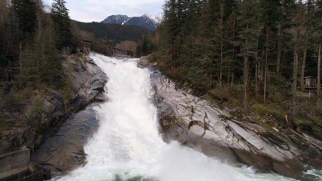 Aerial Dolly of Fresh Fresh Winter Snow Melt Runoff Flowing Down Pacific Northwest Waterfall Slow Motion