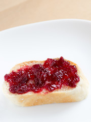 Piece of french bread with cherry jam
