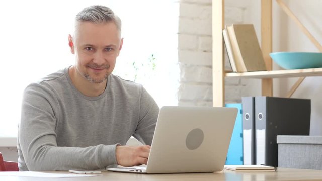 Middle Aged Man at Work Smiling  toward Camera