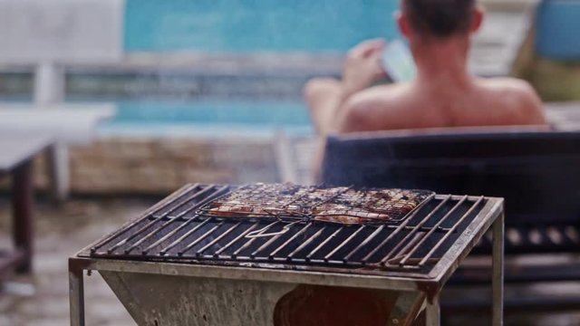 Young Man Catches Telephone with Frying Meat on Foreground