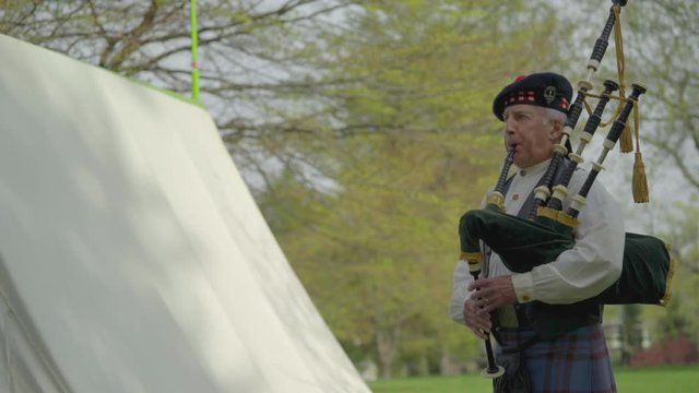 Revolutionary War era piper plays near tent