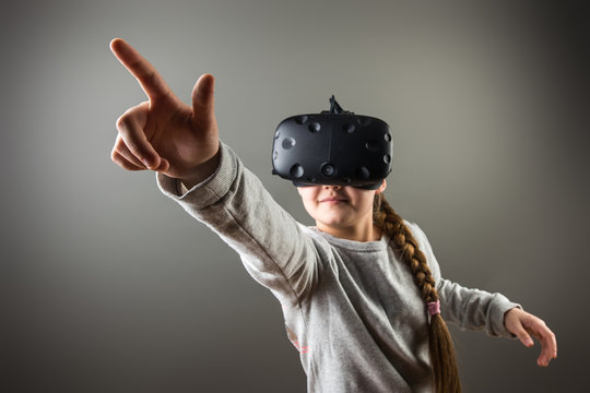 surprised little girl using a virtual reality headset