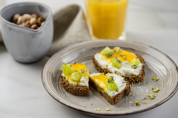 Sandwich with apricot jam and cottage cheese on a white plate, end with copy space