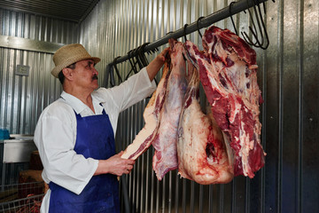 Kazakh butcher at work, cuts meat