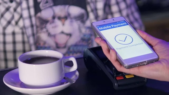 Woman paying a cafe receipe with a smartphone app. 4K.