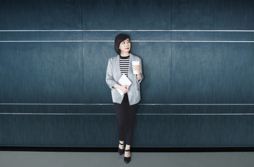 Business working woman standing at the wall