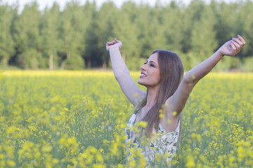 Naklejka premium Beautiful girl in field with hands up