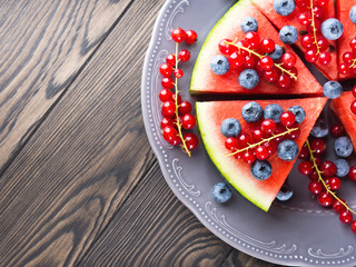 Slice of watermelon served as cake or pizza with fresh berries on rustic background