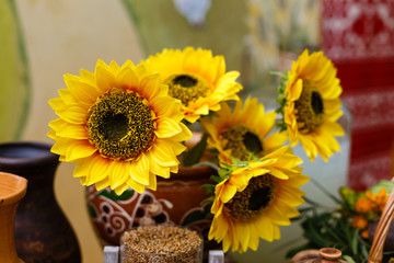 Obraz premium Bouquet of sunflowers in old clay jug. In the foreground branches with ripe cherry plum