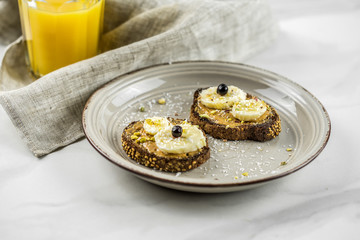 Peanut butter spread on bread, healthy and fresh protein food Sandwiches with peanut butter, jam and fresh fruits on white wooden background from top view