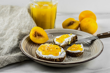 Sandwich with apricot jam and cottage cheese on a white plate, end with copy space