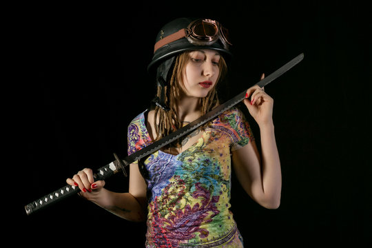 Female gothic warrior in pilot old glasses posing with katana sword