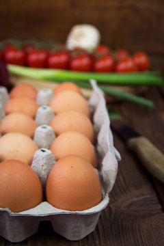 Chicken eggs in carton on wooden background
