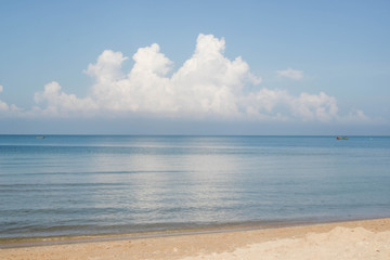 Blue ocean with big clouds on blue sky.