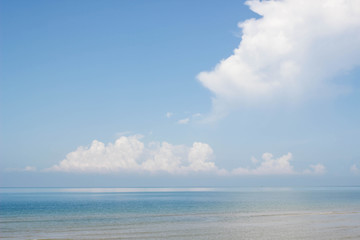 Blue ocean with big clouds on blue sky.