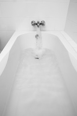 Luxury bath tub and faucet with water.
