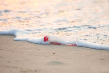 Discarded water bottle laying on a beach.