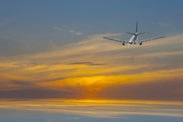 Airplane in the colorful sunrise sky background.