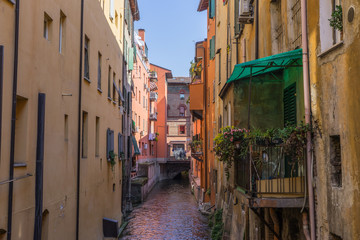 Fototapeta na wymiar Colorful water canal in downtown Bologna, Italy