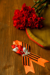 Carnation, George Ribbon, military binoculars and field cap