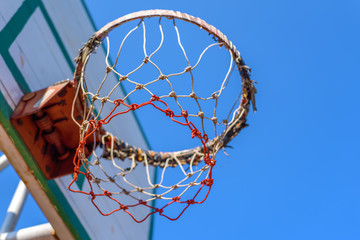 Basketball hoop with blue sky.