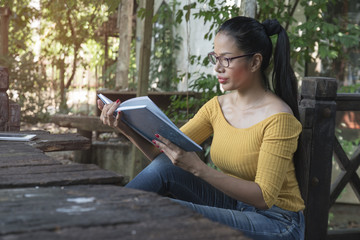 Fototapeta premium woman sitting in her home garden reading a book