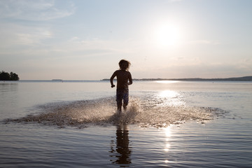 Young boy running in water