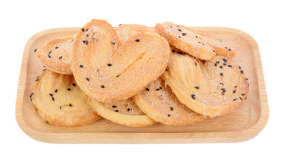 Black heart sesame biscuit in wooden plate isolated on white background