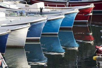 Fototapeta na wymiar Bows of small fisherman boats in perspective.