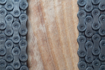 Dirty and oily chain from a mountain bike lying on a wooden table in a bicycle shop