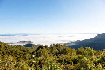 Clouds in the mountains lit by the sun. The view from the top.