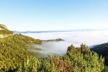 Clouds in the mountains lit by the sun. The view from the top.