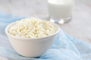 Cottage cheese in a bowl and glass of milk