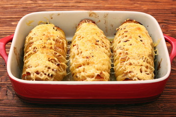 Sliced baked potatoes with cheese and bacon
