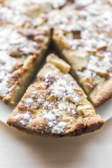 Apple pie and a cut piece of pie with powdered sugar