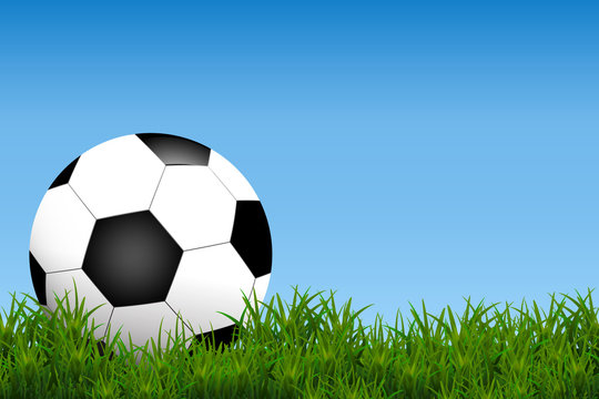 Football, soccer Ball Isolated on Grass field ad blue Background with Space for Your Text.