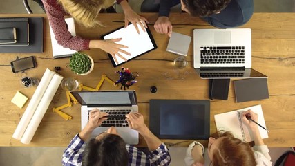 Top overhead view people group using tablet on a design project idea. Creative modern business team work meeting an at agency office. 4k indoor technology video