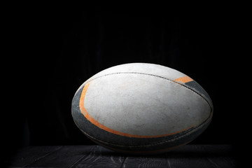 Old rugby ball on a black background