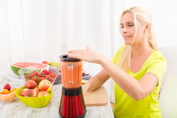 Mature woman blending a smoothie.....