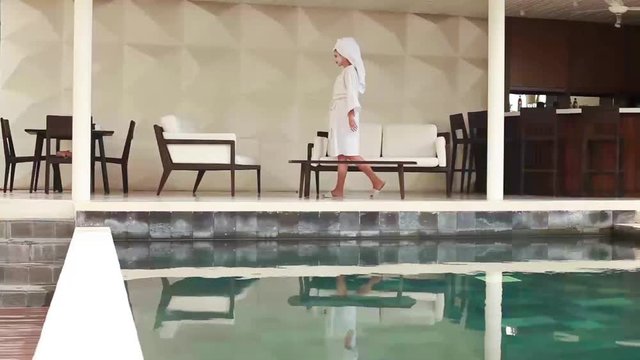 Woman having a facial treatment while sitting next to the pool