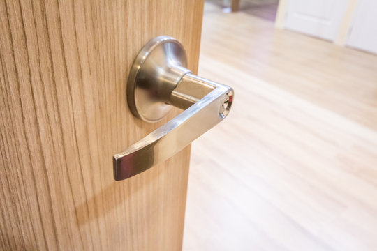 Modern style door handle on natural wooden door