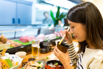 Young woman having dinner in japanese restaurant