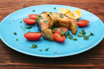 Steak of sturgeon with lemon and tomatoes