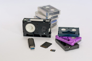 MiniDV  and  VHS video tape isolated on white.  SD and MicroSD cards. Cassettes. USB 3.0 pendrive.