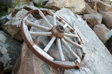 old wagon wheel on a rock