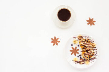 Breakfast with pate of belgian waffles with fresh fruit, chocolate, banana, berry, blueberries, cup of black coffee on white background. Flat lay, top view, mock up