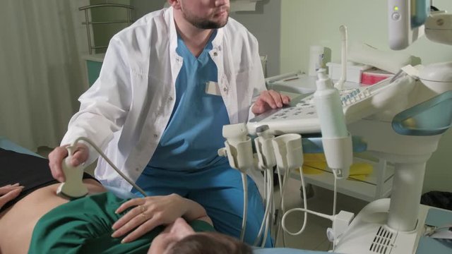 Doctor doing 3d ultrasound on belly of t woman in clinic 4k